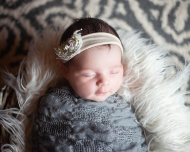 Sioux Falls newborn posing in basket with fur