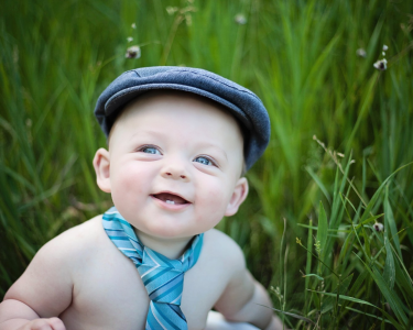 Sioux Falls boy posing with newspaper boy hat in field